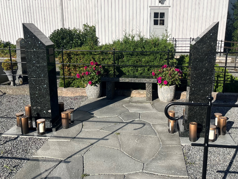 Navnet minnelund på Hisøy kirkegård med navnetavle og beplantning.